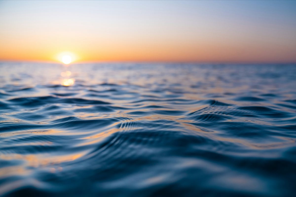 Il mare al tramonto visto a pelo d'acqua, con il sole sull'orizzonte