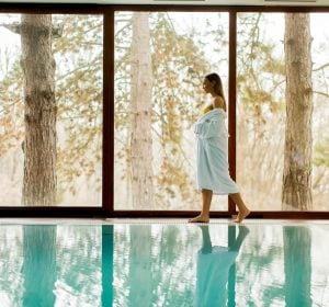 Pretty young woman standing by swimming pool